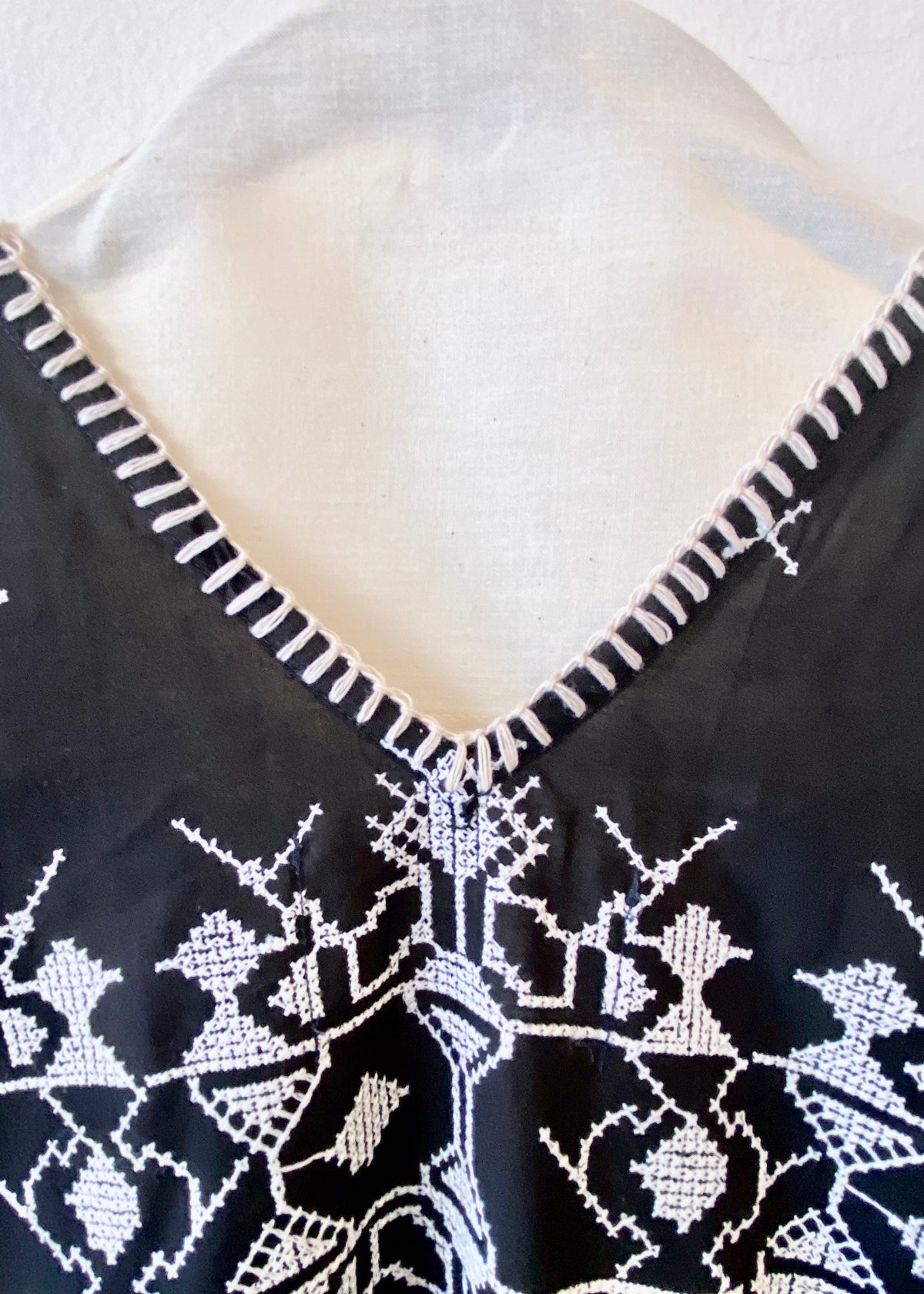 v-neck black caftan with white embroidery blanket stitch detail