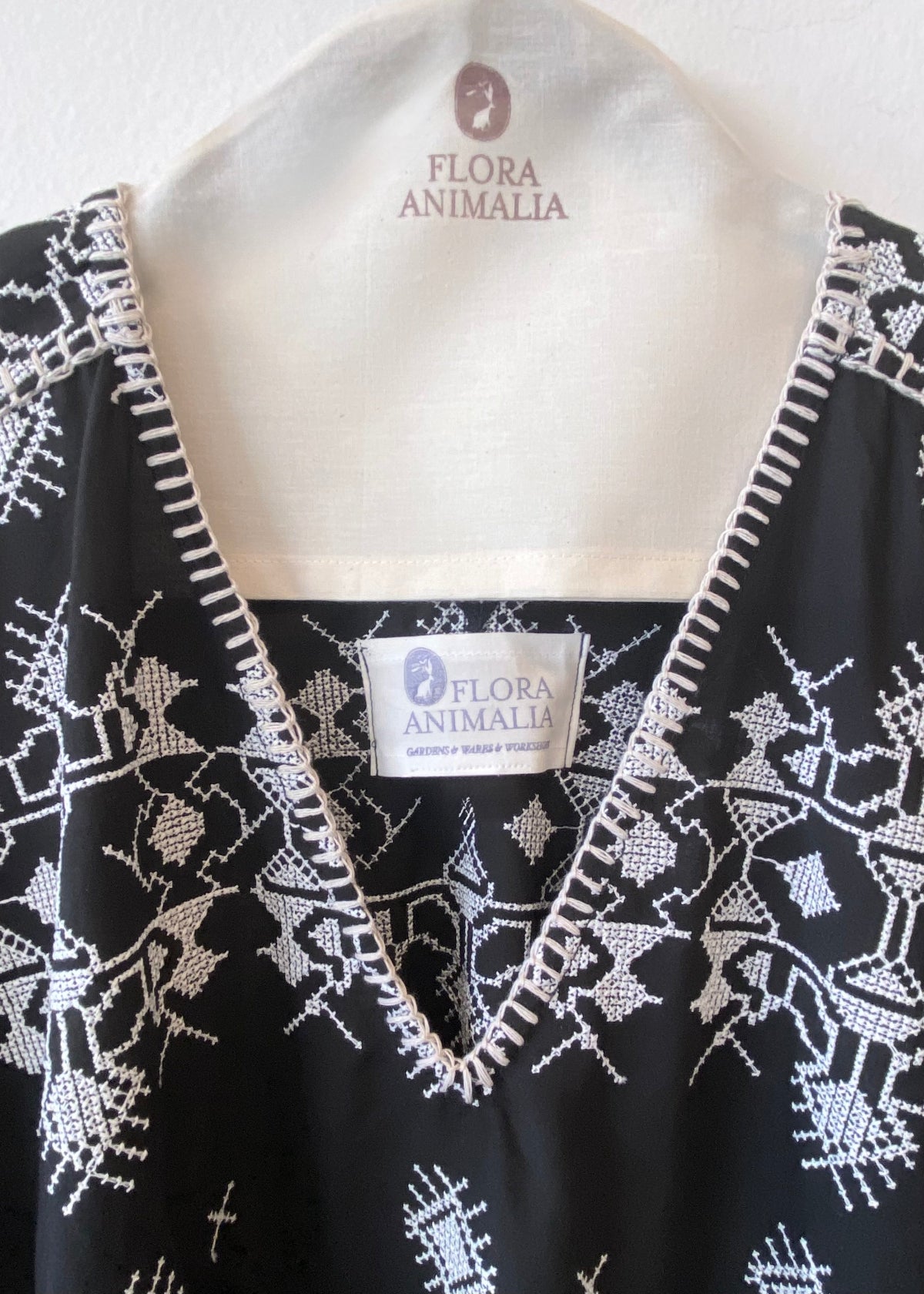 v-neck black caftan with white embroidery blanket stitch detail front