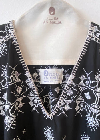 v-neck black caftan with white embroidery blanket stitch detail front