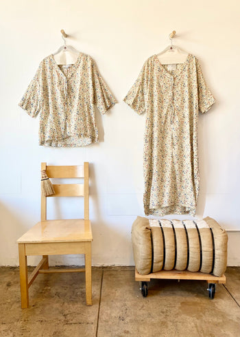 Two patterned shirts on hangers, against a white wall.