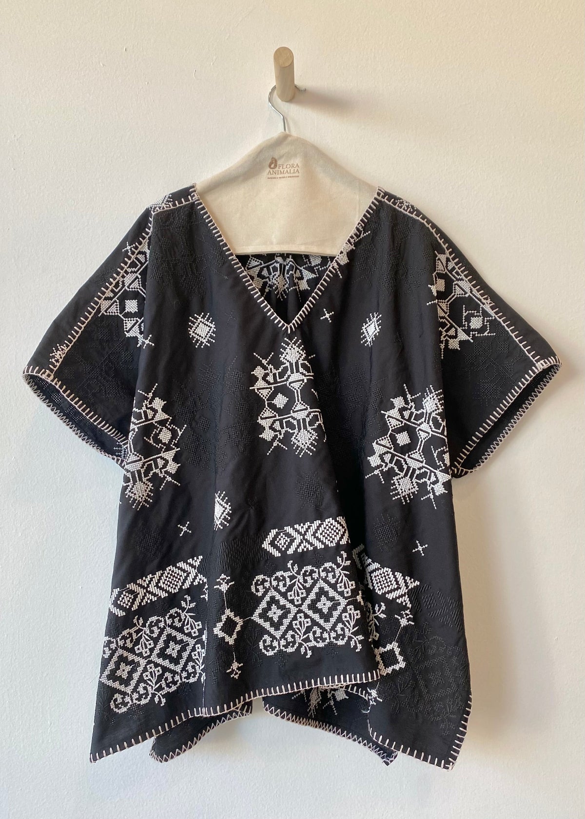 white shirt with eyelet and white embroidery against a white wall