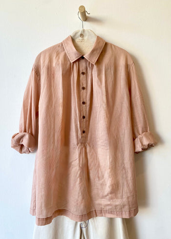 Pink shirt on a hanger against a white wall