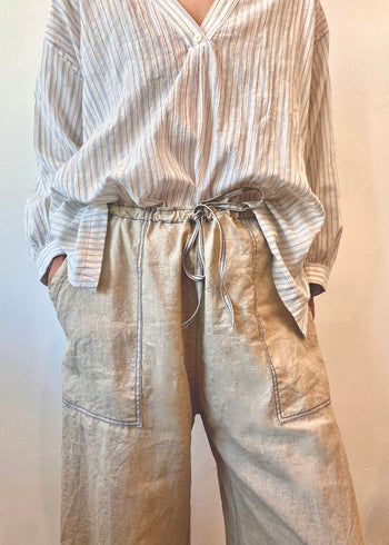 Striped shirt and beige drawstring pants on a plain background