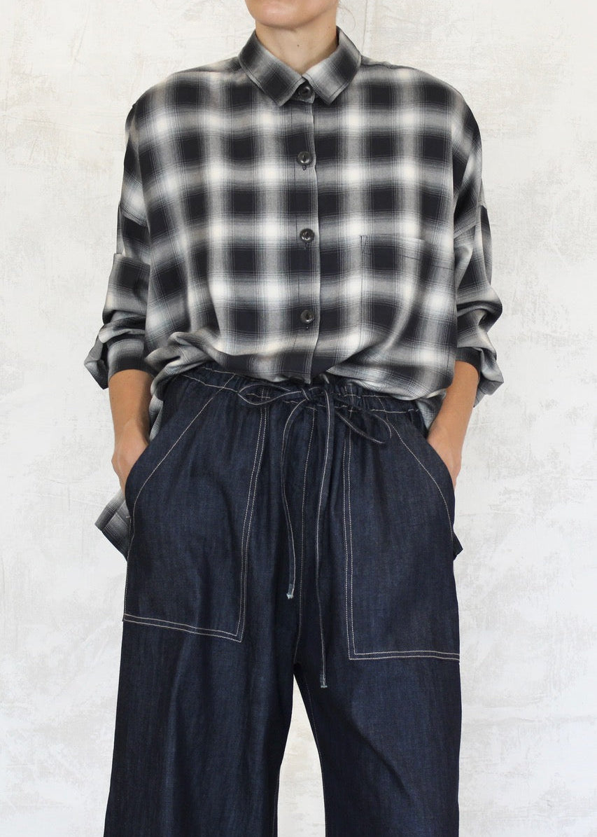 front view of model wearing denim picker's pants with plaid shirt