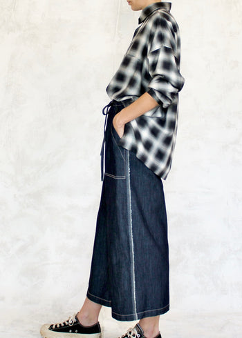 side view of model wearing denim picker's pants with plaid shirt