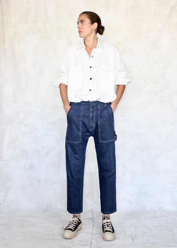 Model wearing white button down shirt and cropped indigo denim Maker's pant