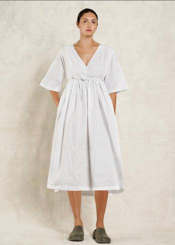 Woman wearing a white dress against a plain background