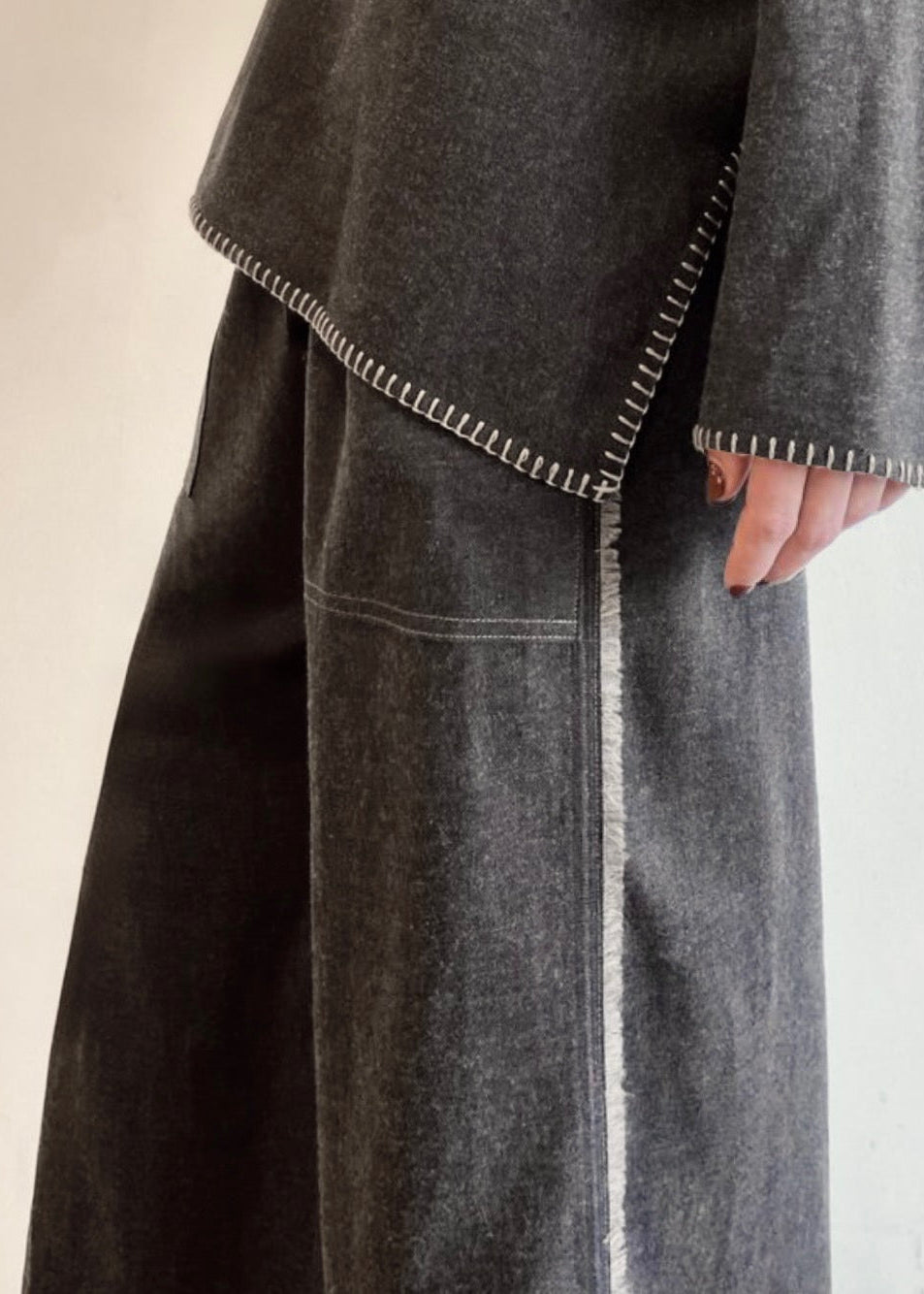 close up side view Charcoal Gray Flannel Picker's pants on a model with a gray flannel shirt with crochet stitching 