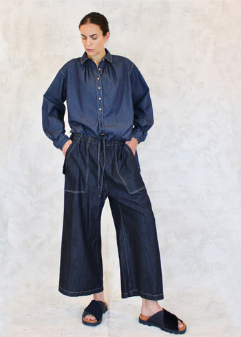button collared denim top tucked into denim drawstring wide legged pants