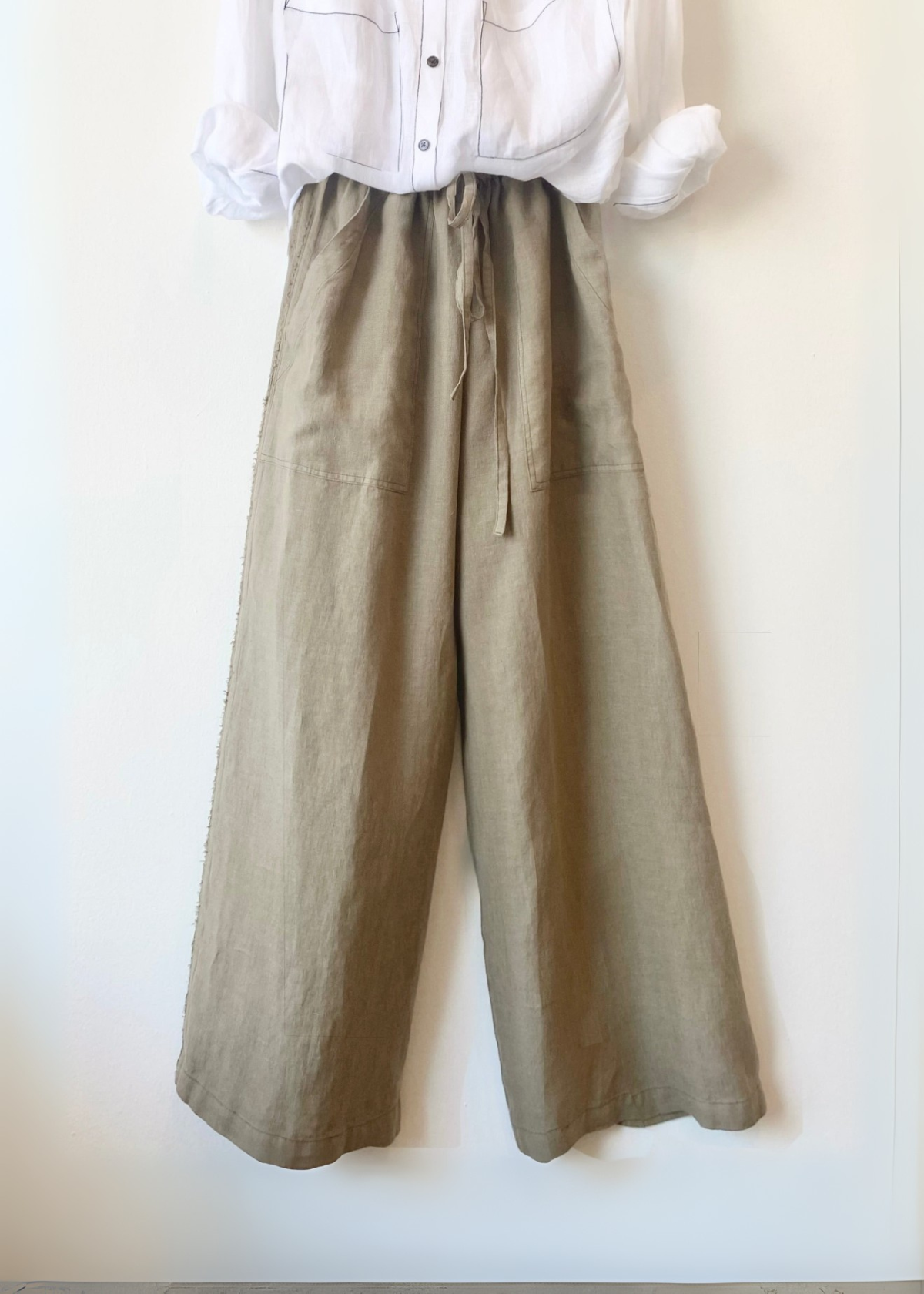 khaki wide-leg pants with a white shirt on a white background