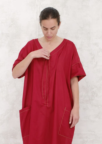 woman in red dress demonstrating how to cinch by using pullstring