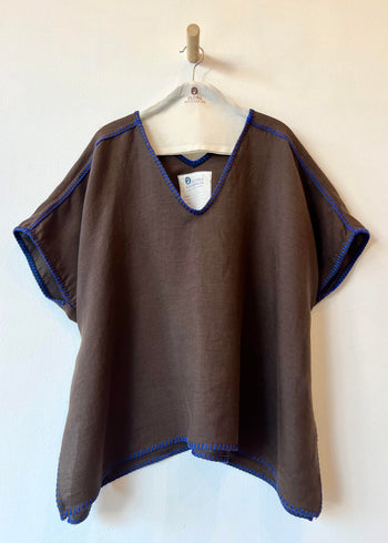 Brown poncho with blue trim on a hanger against a white background